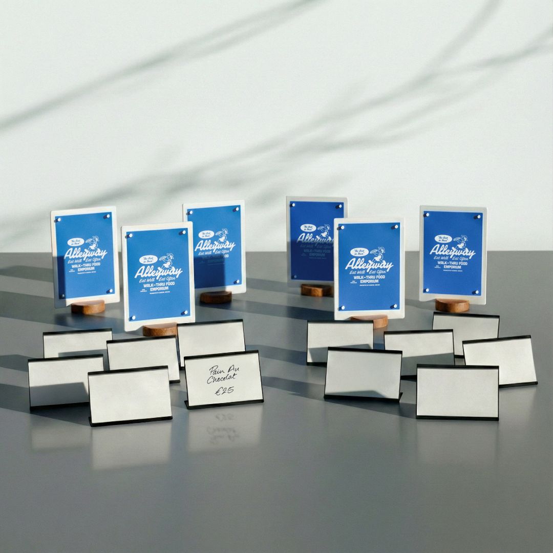 Set of framed certificates or awards with blue and white design on a reflective surface.