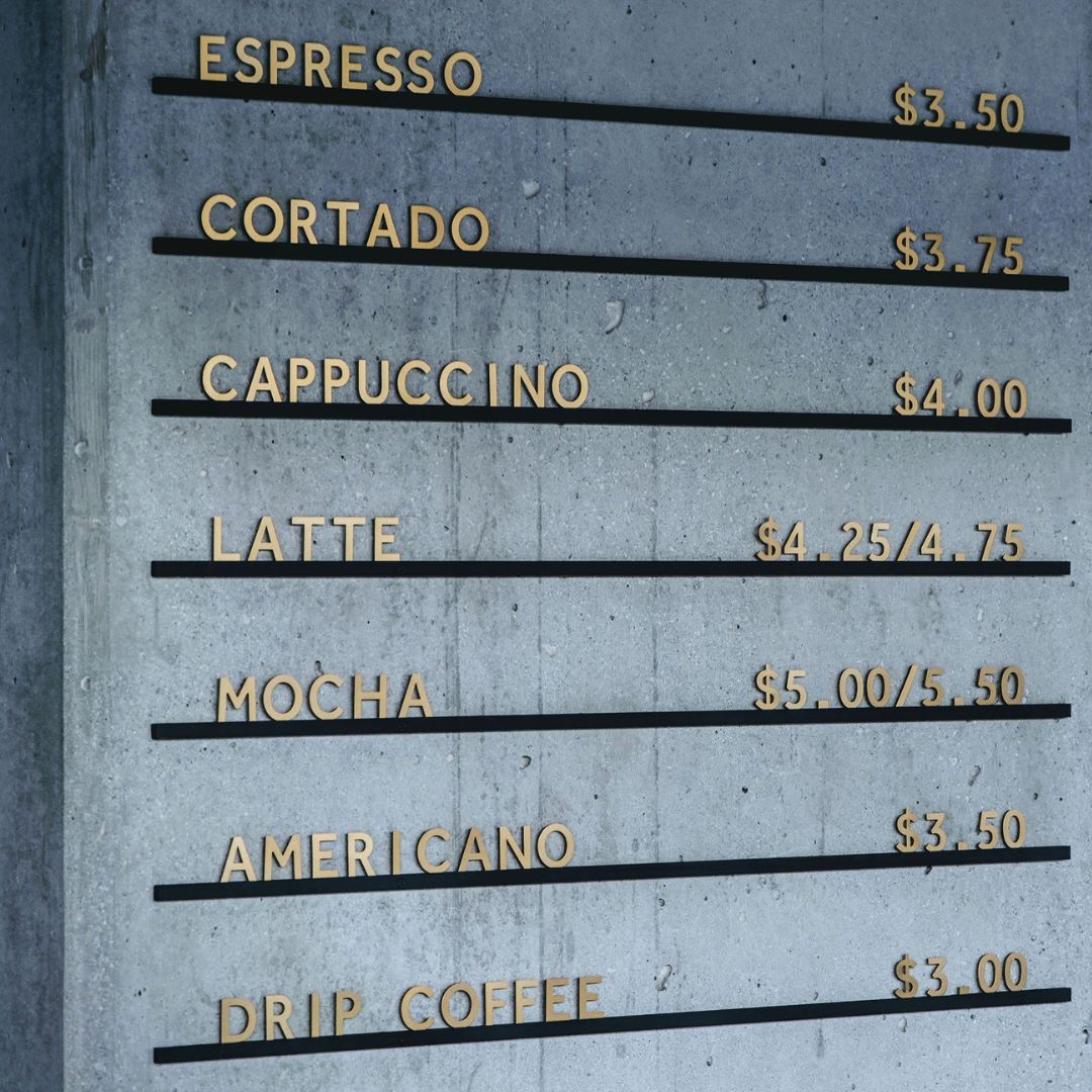 Aluminium Atelier Letter Board attached to a navy blue wall showing coffee menu items