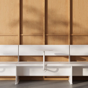 white booth seats sitting alongside each other with wall mounted cafe tables attached