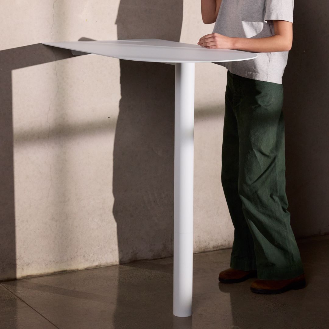 Café customer standing at bar leaner at wall-mounted aluminum booth restaurant table showcasing height