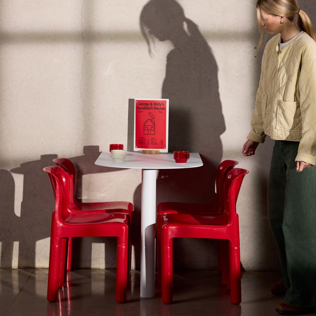 White aluminum booth restaurant table and red chairs set in modern restaurant space at standard cafe table height