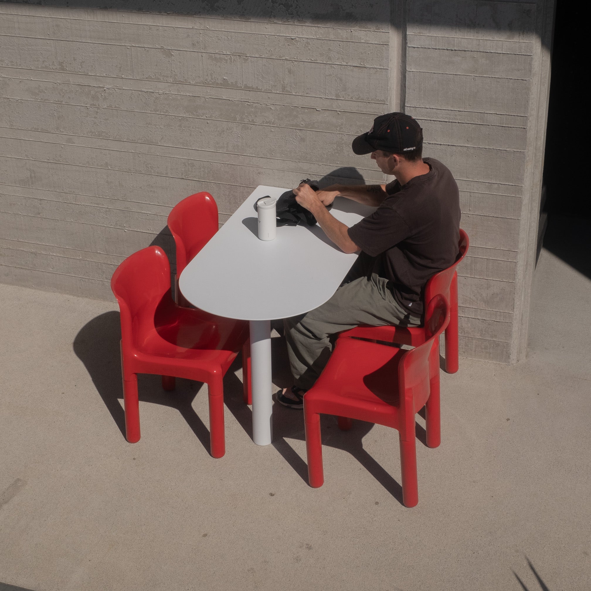 Diners seated at a white booth cafe table outside contemporary café with red chairs