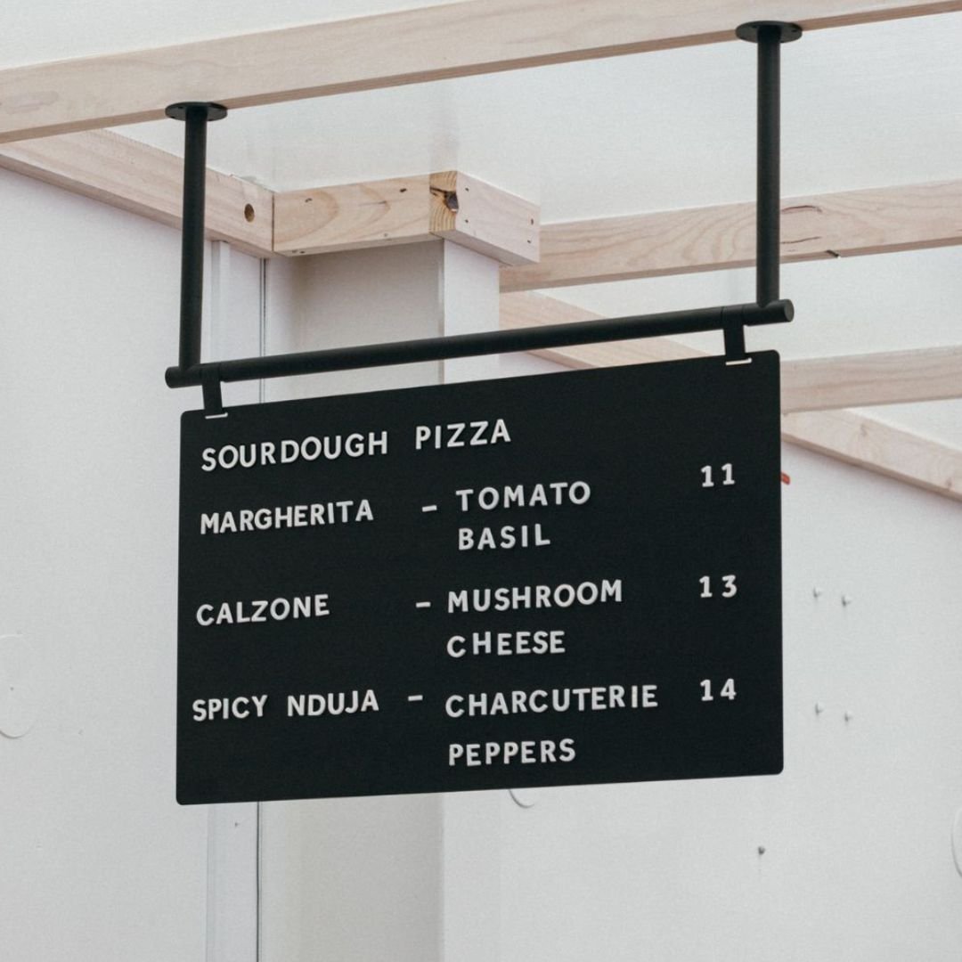 black ceiling mounted menu board mounted onto wooden ceiling railing