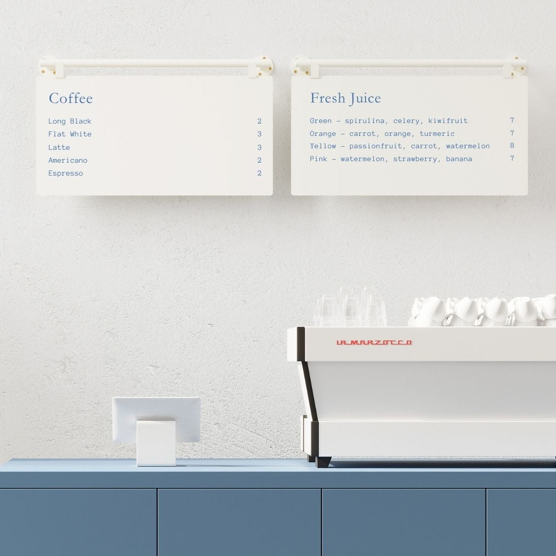 two white ceiling mounted menu boards side by side behind a countertop