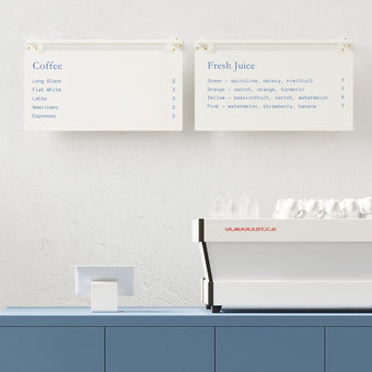 two white ceiling mounted menu boards side by side behind a countertop