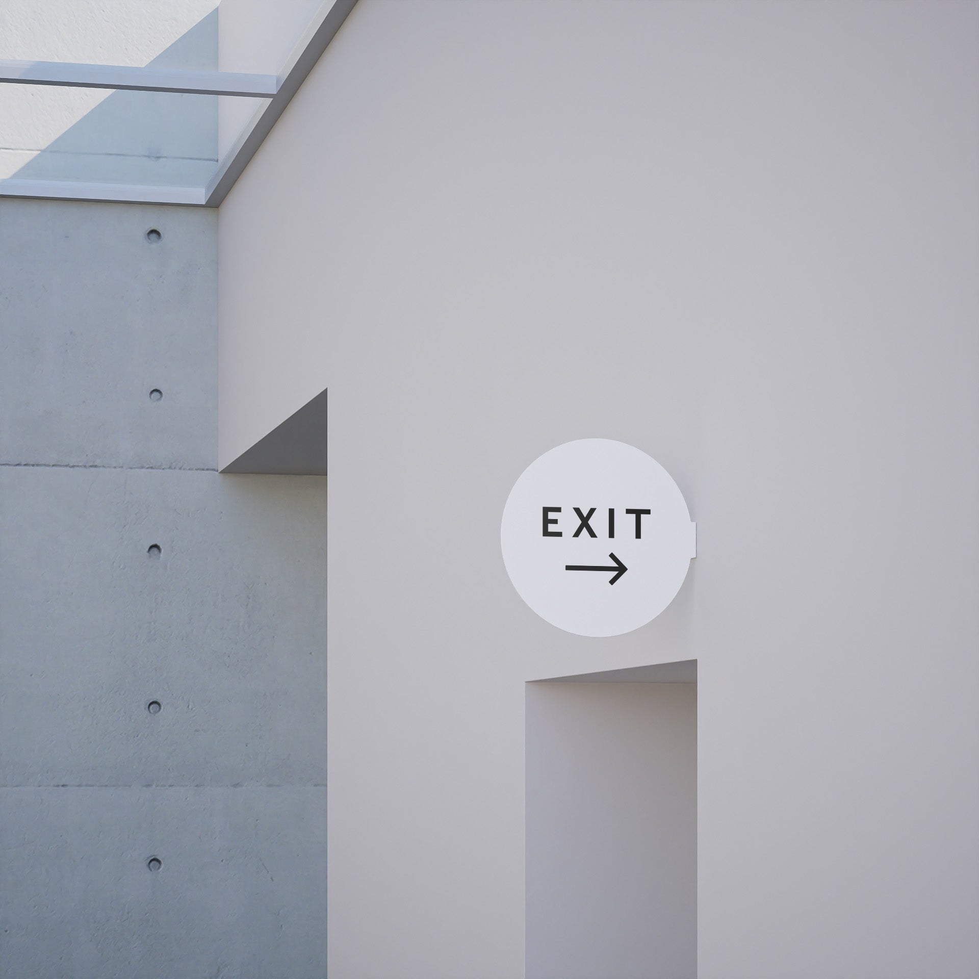 white circle blade wall sign with toilet decal applied to be a bathroom sign, installed on a wall
