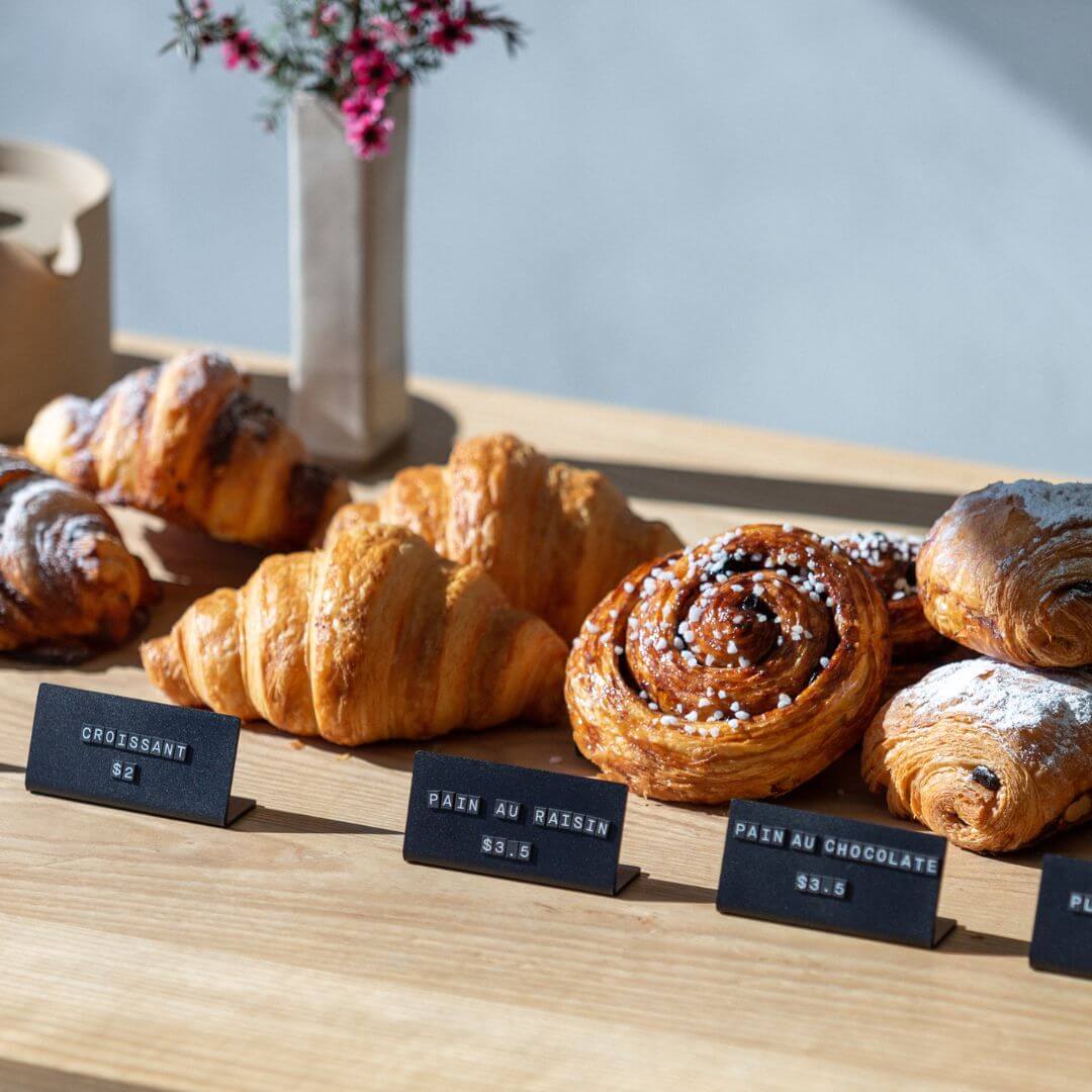 countertop with small menu displays with croissants behind