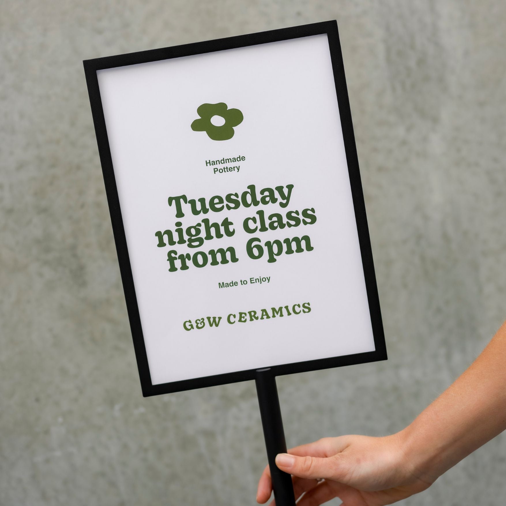 hand lifting the standing sign holder with photo showing close up of the frame and poster displayed