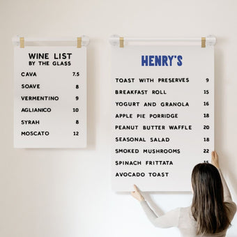 two different sizes of hanging menu boards side by side, with person holding the larger board