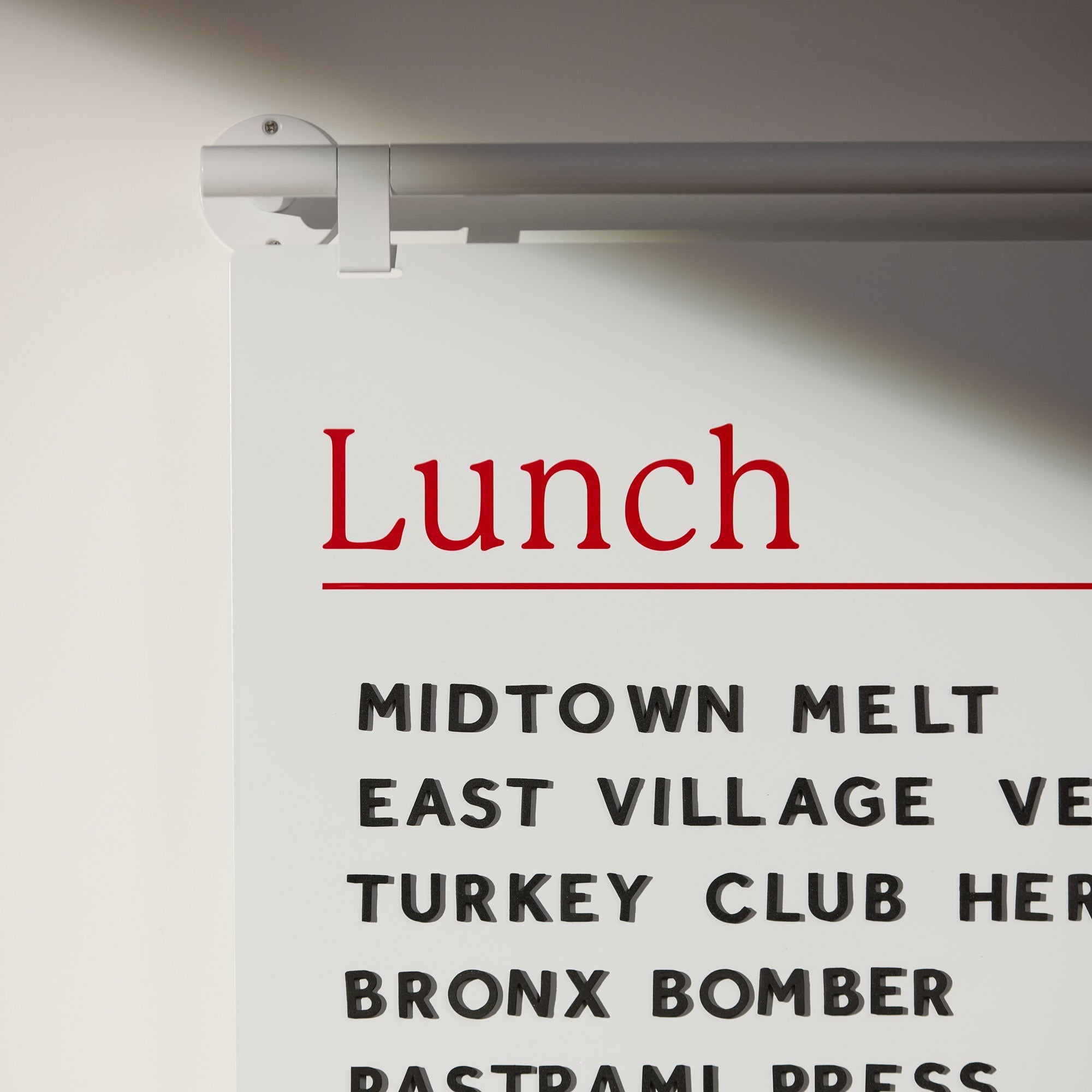 close up of white handing menu board showing hook details