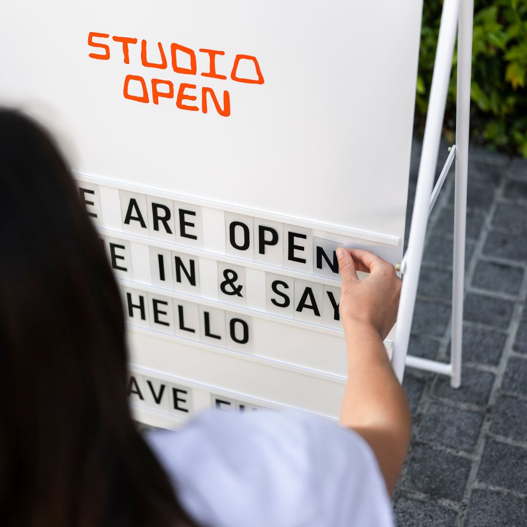 close up of person rearranging the letters on their large white letter a-frame sidewalk sign