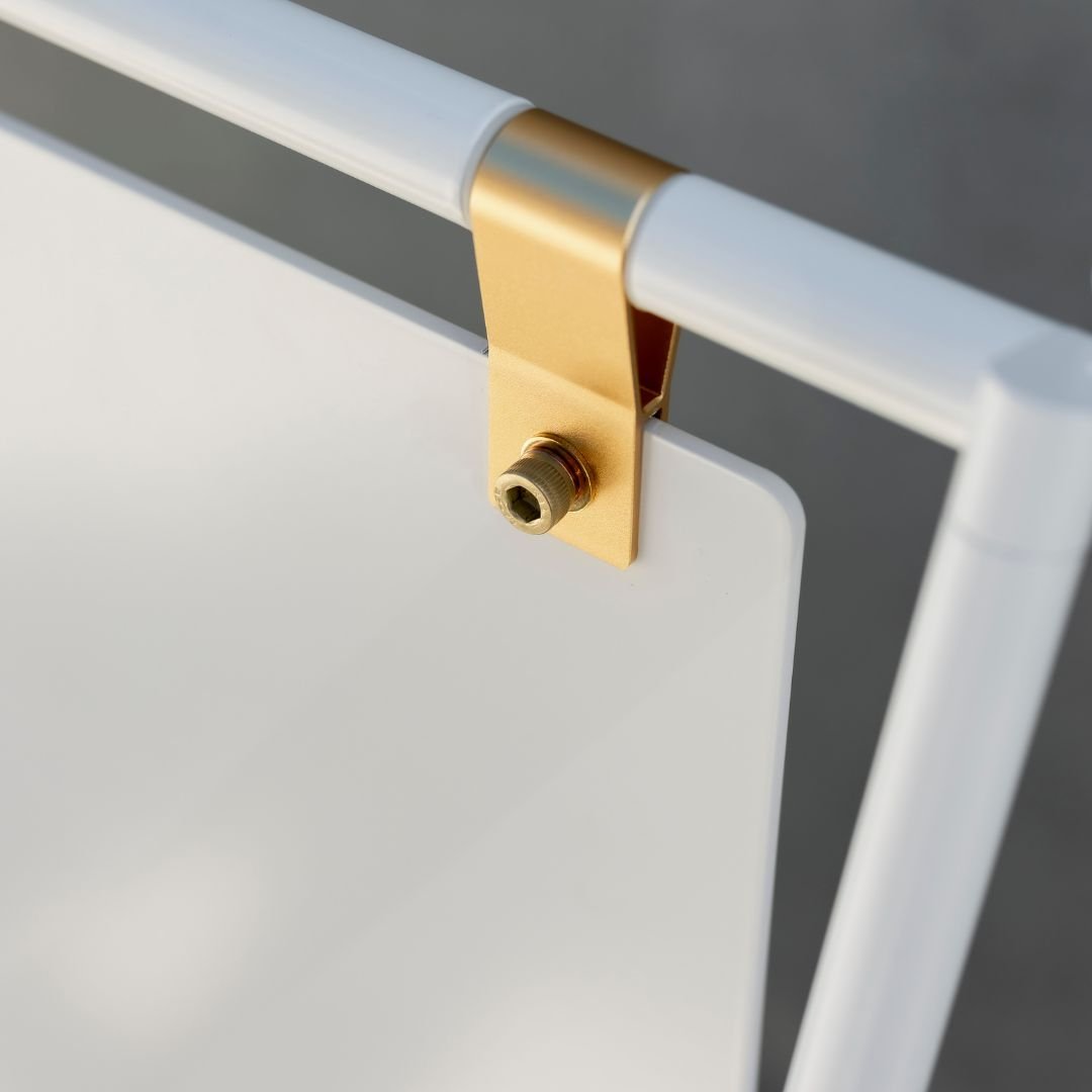 close up of brass straps on white large letter sidewalk sign