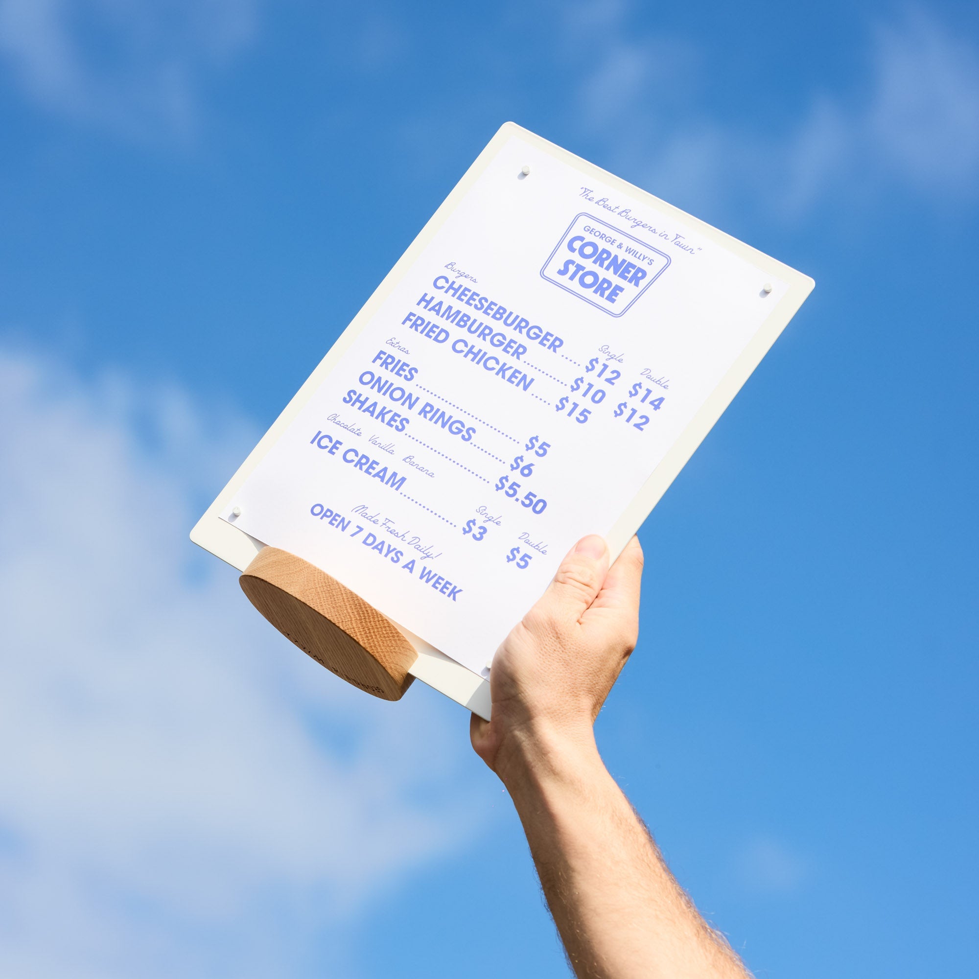 hand holding a white table talker with wooden base up to the sky