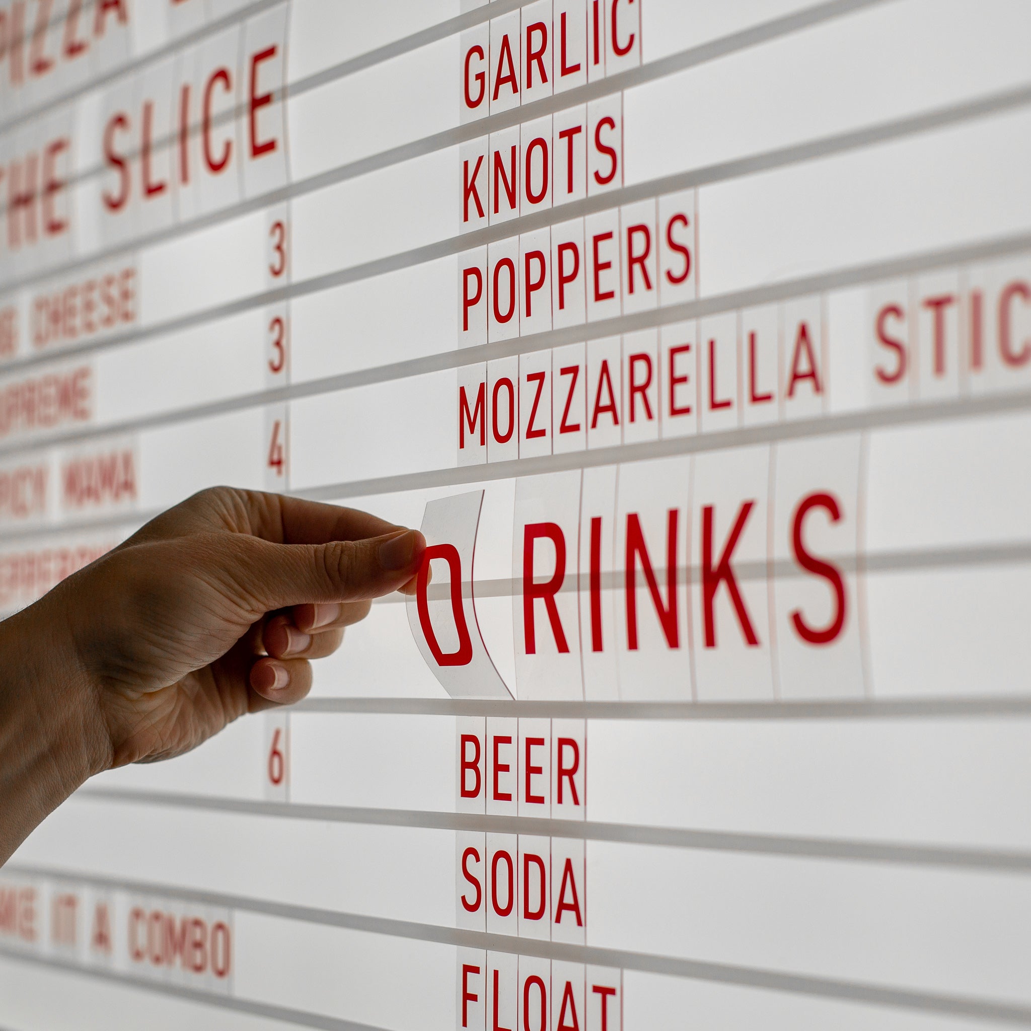 closeup showing the red letter light box menu letters being popped into the grooves