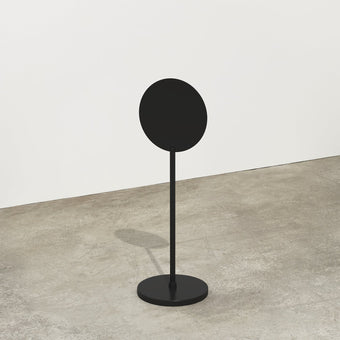 black metal standing round sign in a studio