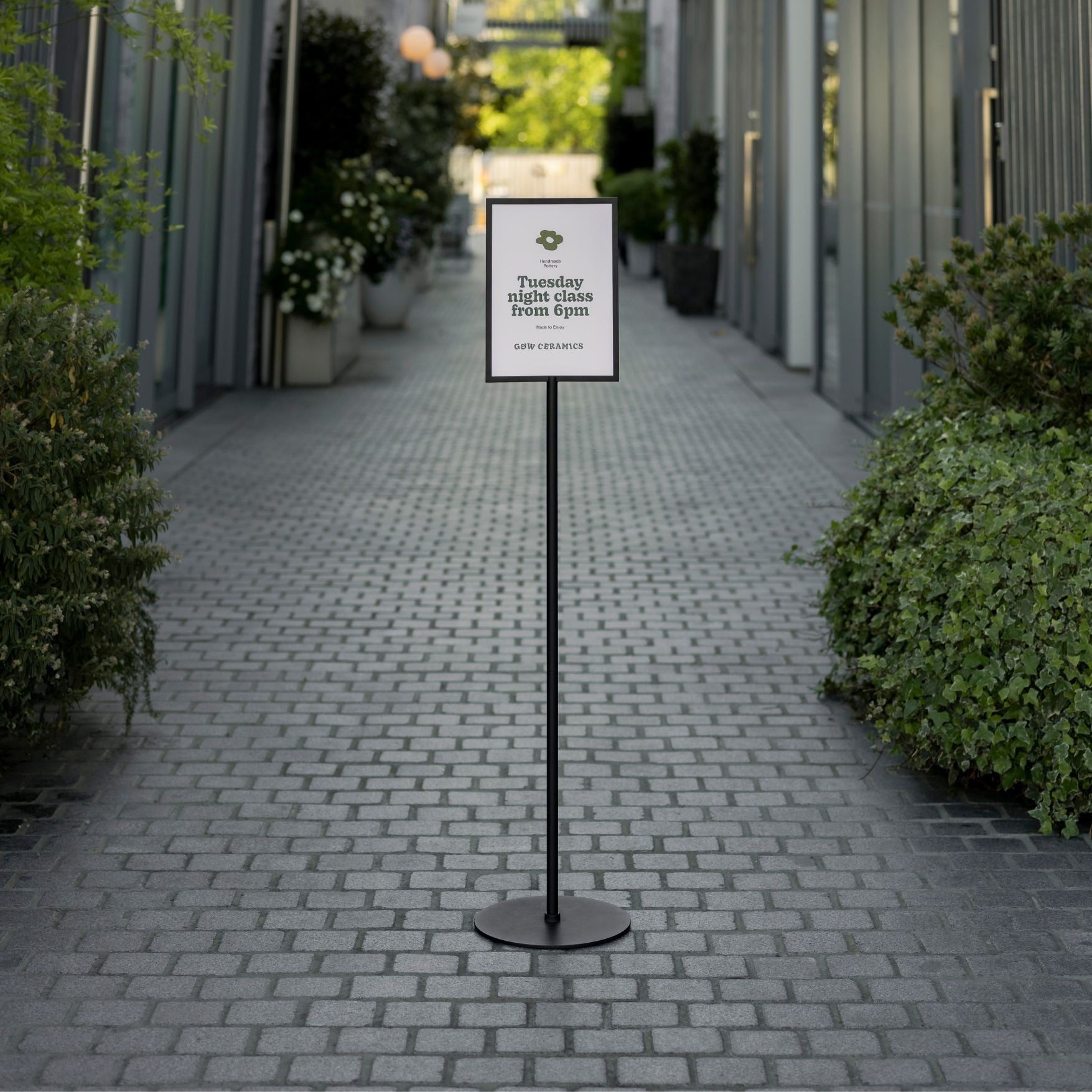 black standing sign holder in an alleyway showing a logo poster displayed