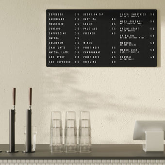 Large black peg letter board with café menu in white letters, mounted on wall above cafe counter