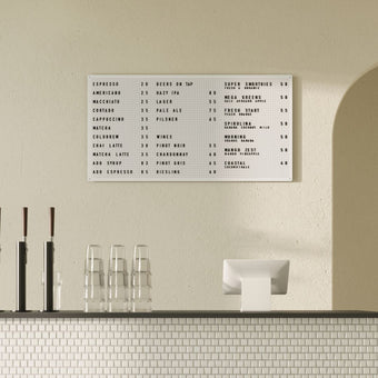 Large steel white peg letter board with menu display, wall-mounted in modern café interior