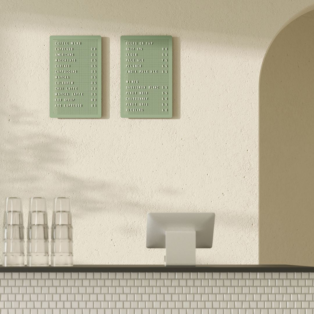 Sage green peg letter board with café menu, attached to wall in neutral interior