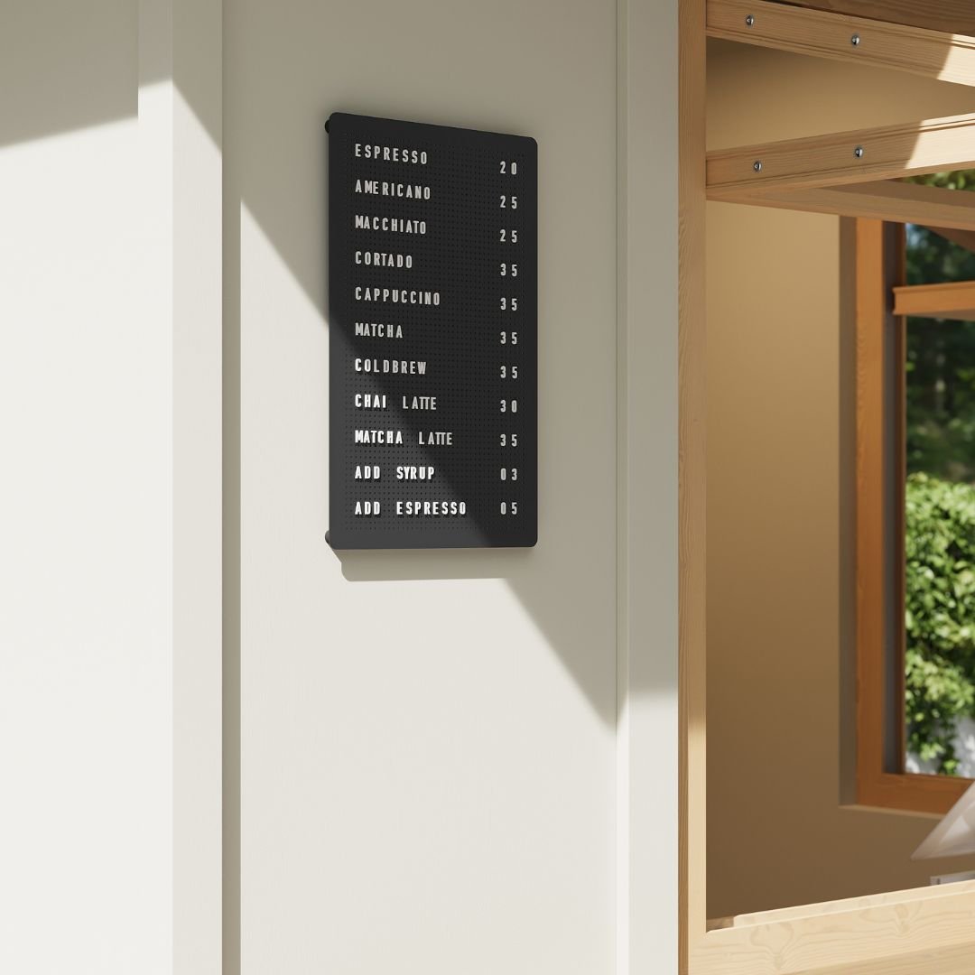 Wall-mounted black peg letter board with white letters in minimalist setting