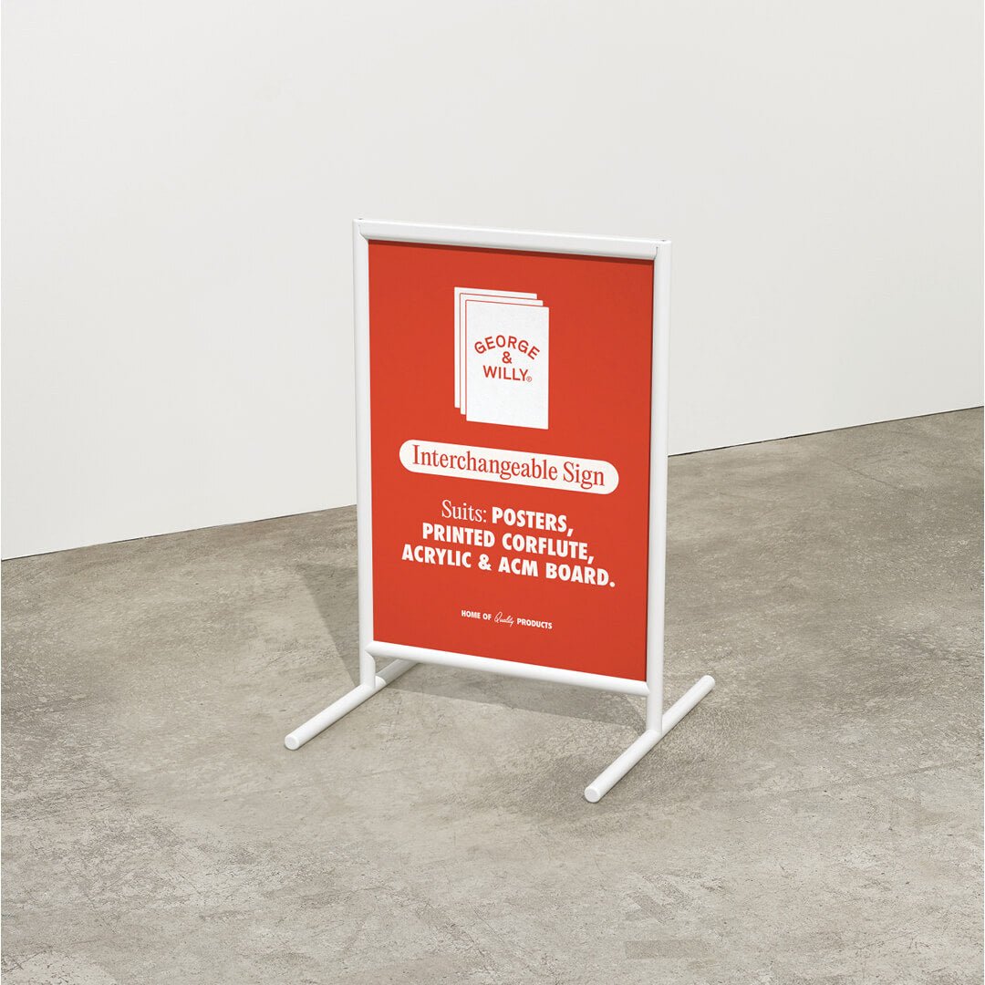 white framed poster sidewalk sandwich board sign with red poster inside on a pavement