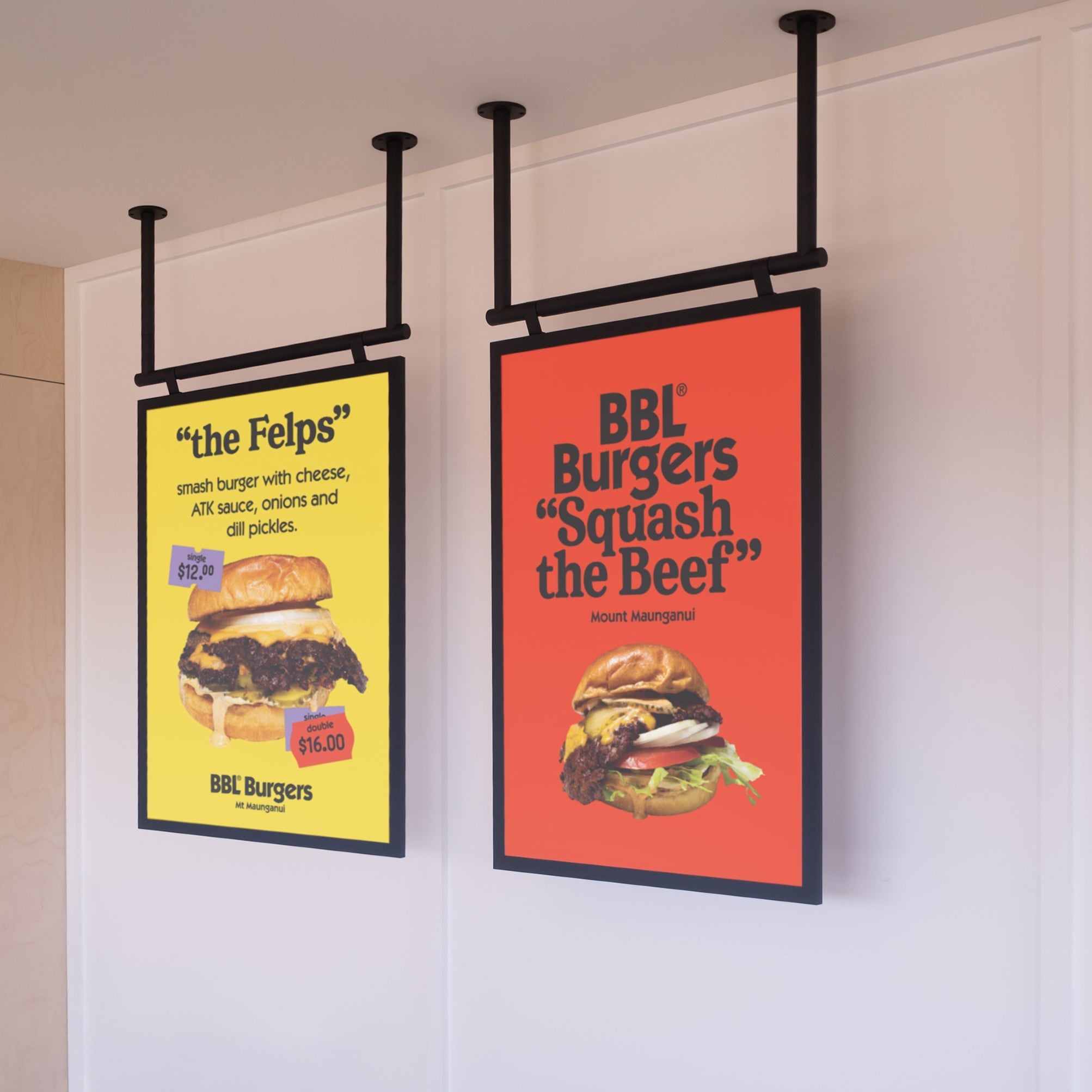 two black poster hanging menu boards installed side by side displaying burger specials