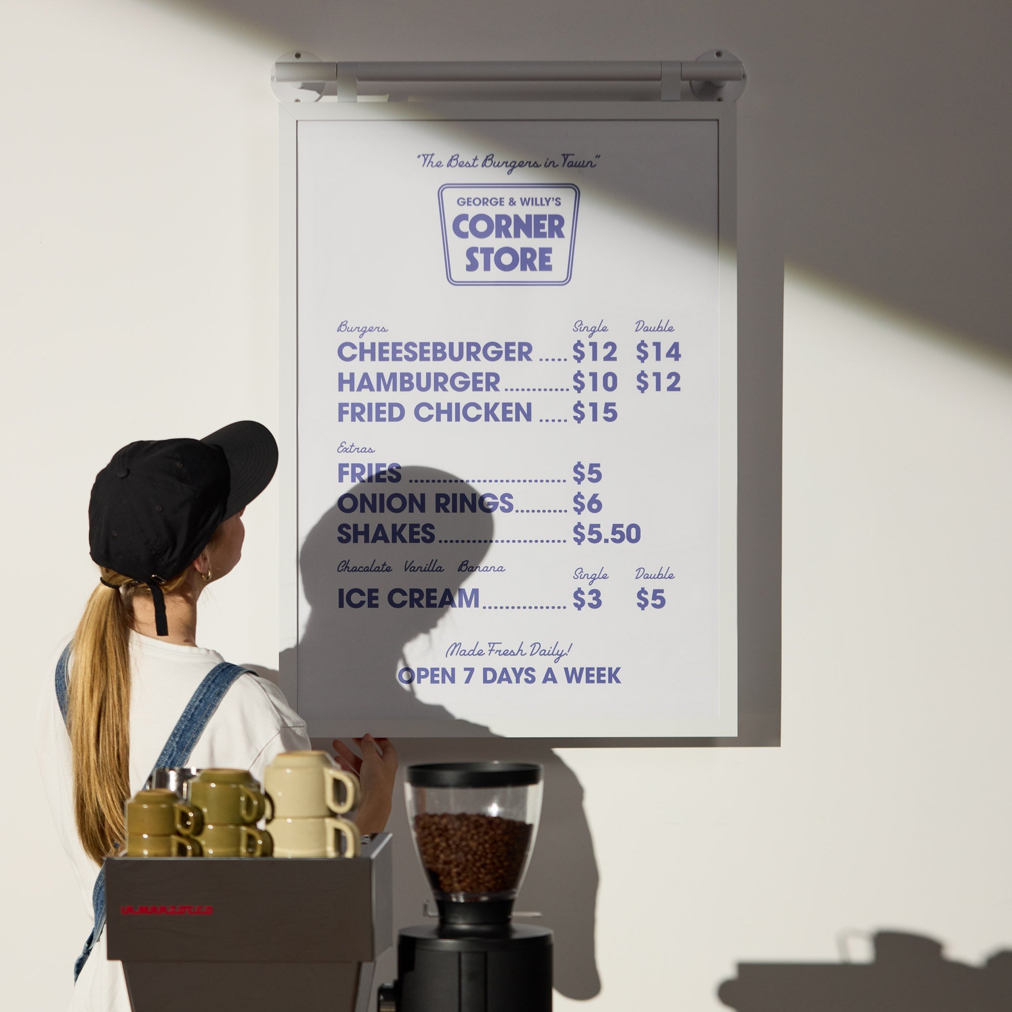 person looking at white poster hanging menu board displaying coffee menu