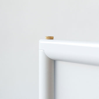 close up of the top corner of the poster sidewalk sign and the brass bolt used