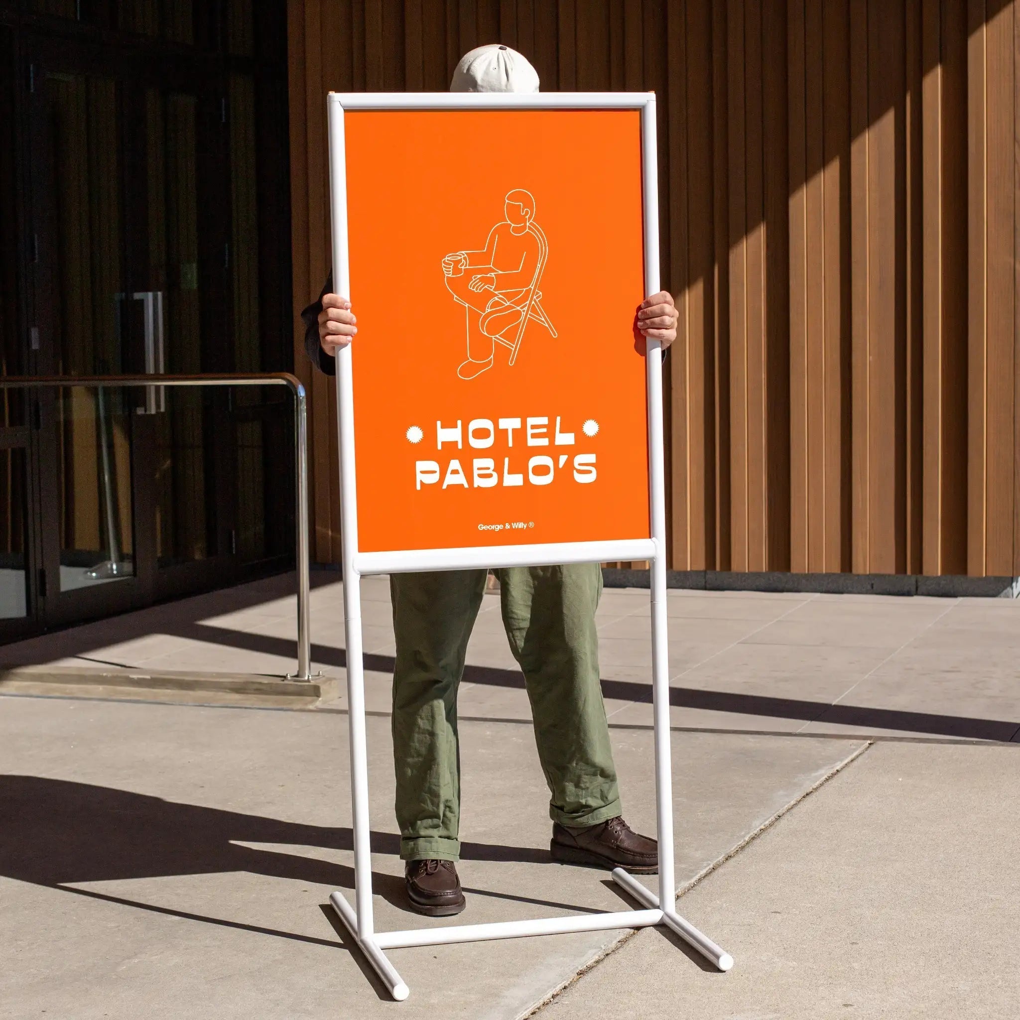 person carrying the tall poster sidewalk sign with a red poster inserted