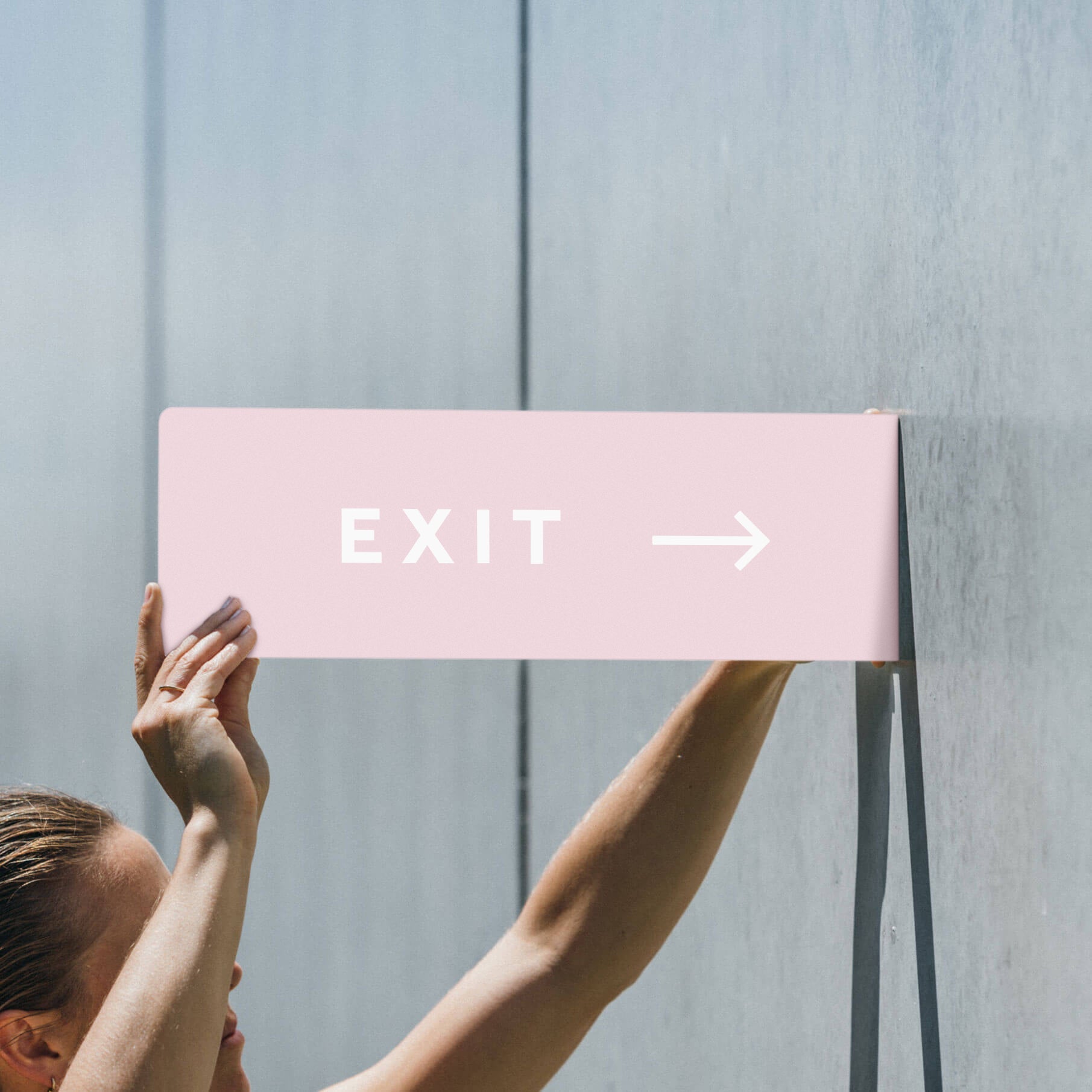 two hands holding up the pink blade sign with "EXIT" on it