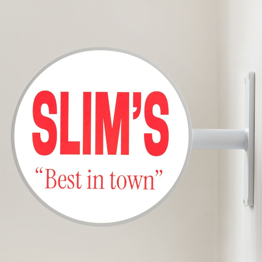 white round light box wall sign installed inside with "slim's" red logo branding on the panel
