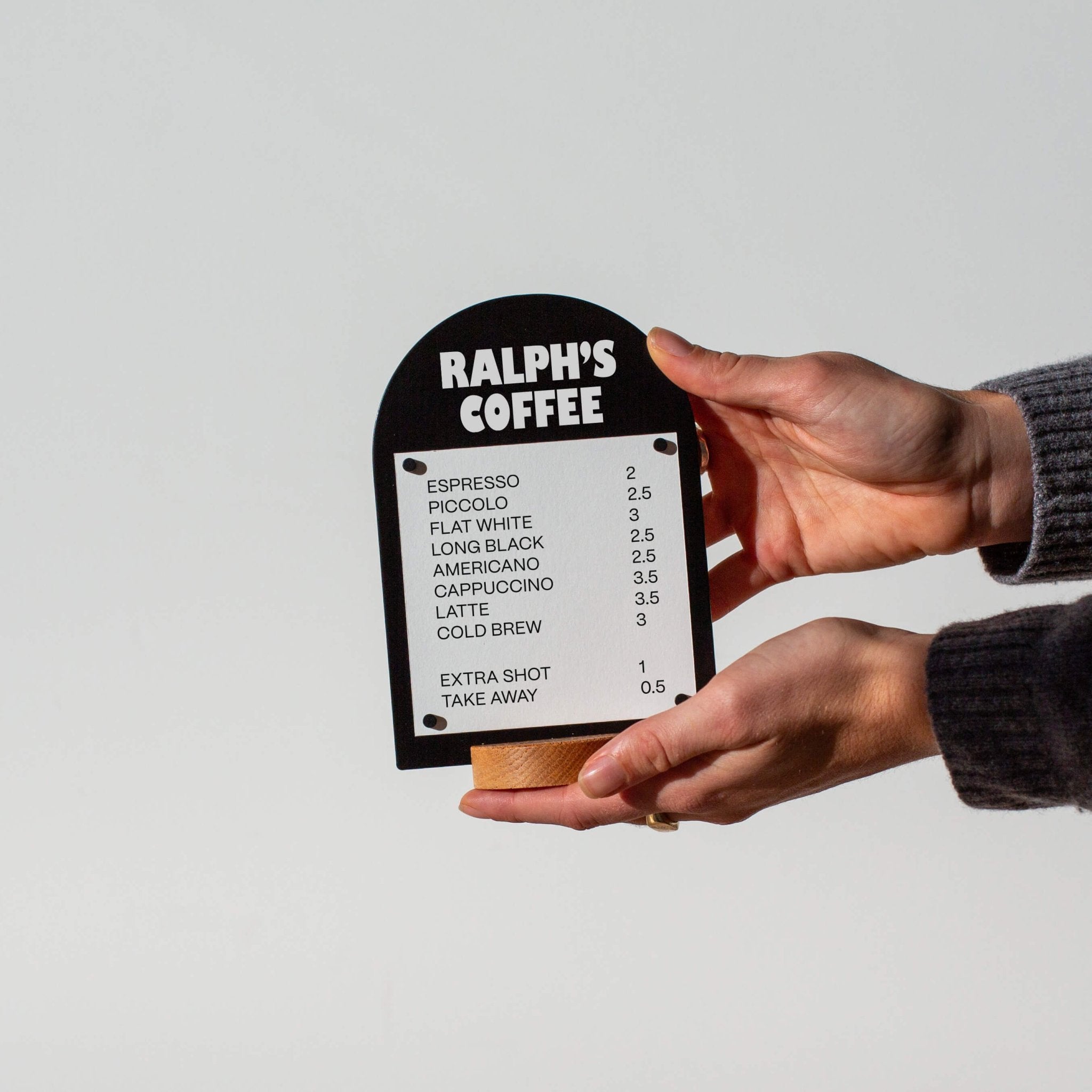 two hands holding a black table talker
