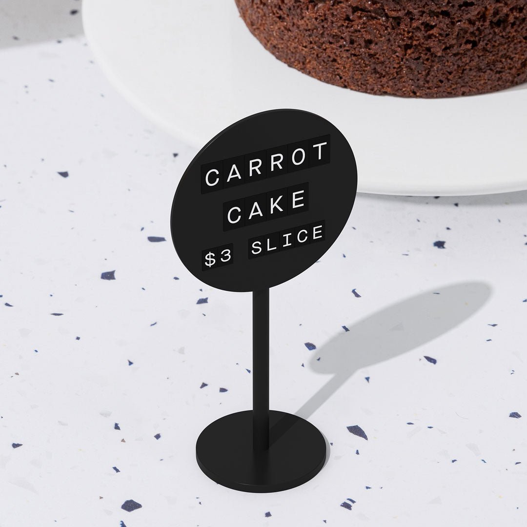 black standing circle sign with retail pricing for a pastry on it