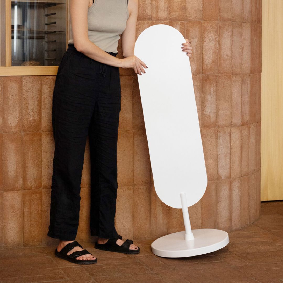 person holding a white large standing curve sign on a lean