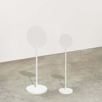two sizes of white standing round sign side by side in studio