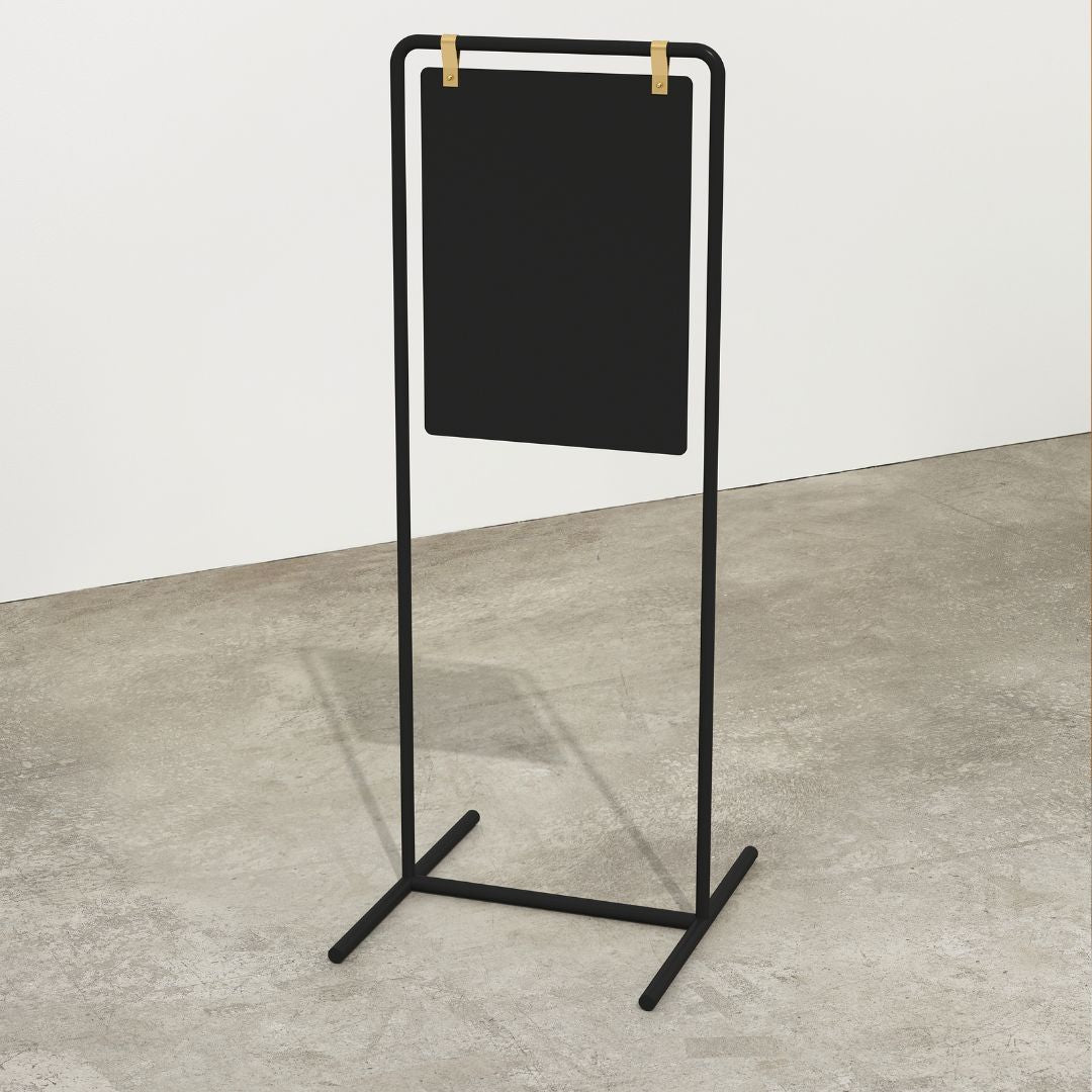 plain black metal pavement swing sign in tall orientation inside a studio