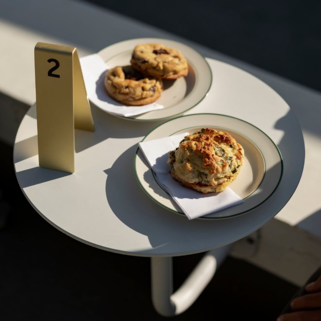 Metal table number stacker placed beside pastries on wall mounted table at cafe