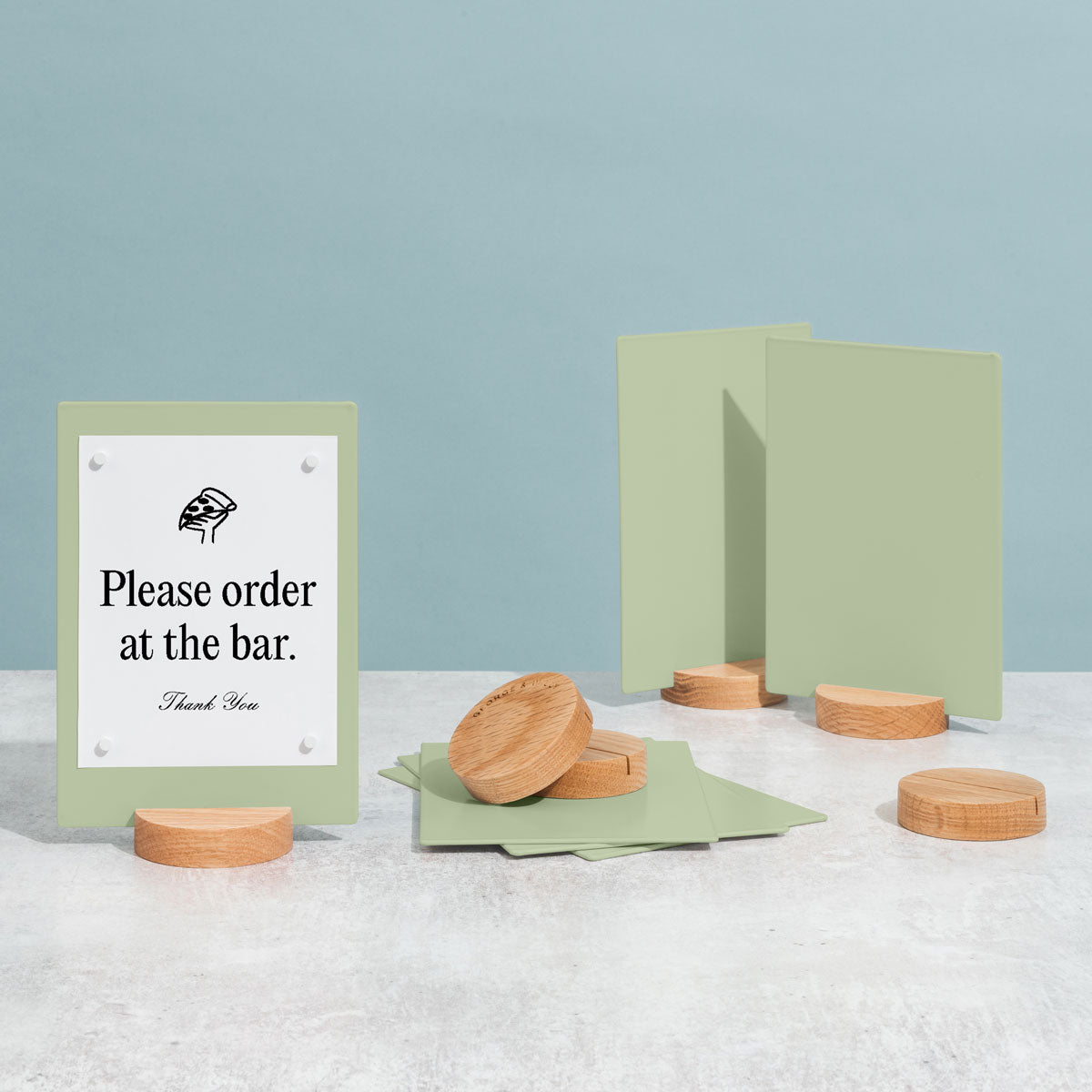 three table talkers in sage green and extra bases on a tabletop
