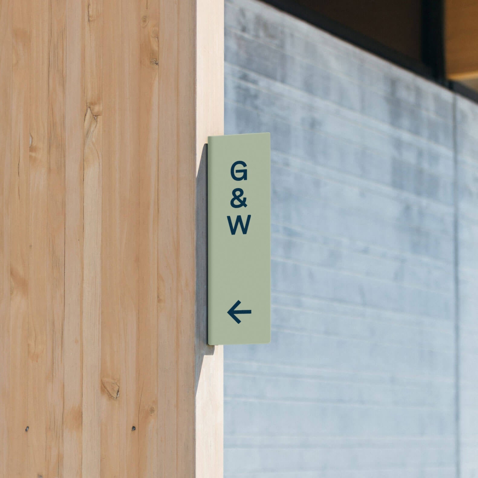 sage green vertical retail store blade restroom sign installed on wooden beam