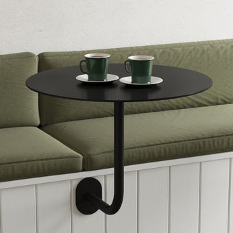 wall-mounted restaurant table in black with round cafe table top, attached to booth seat