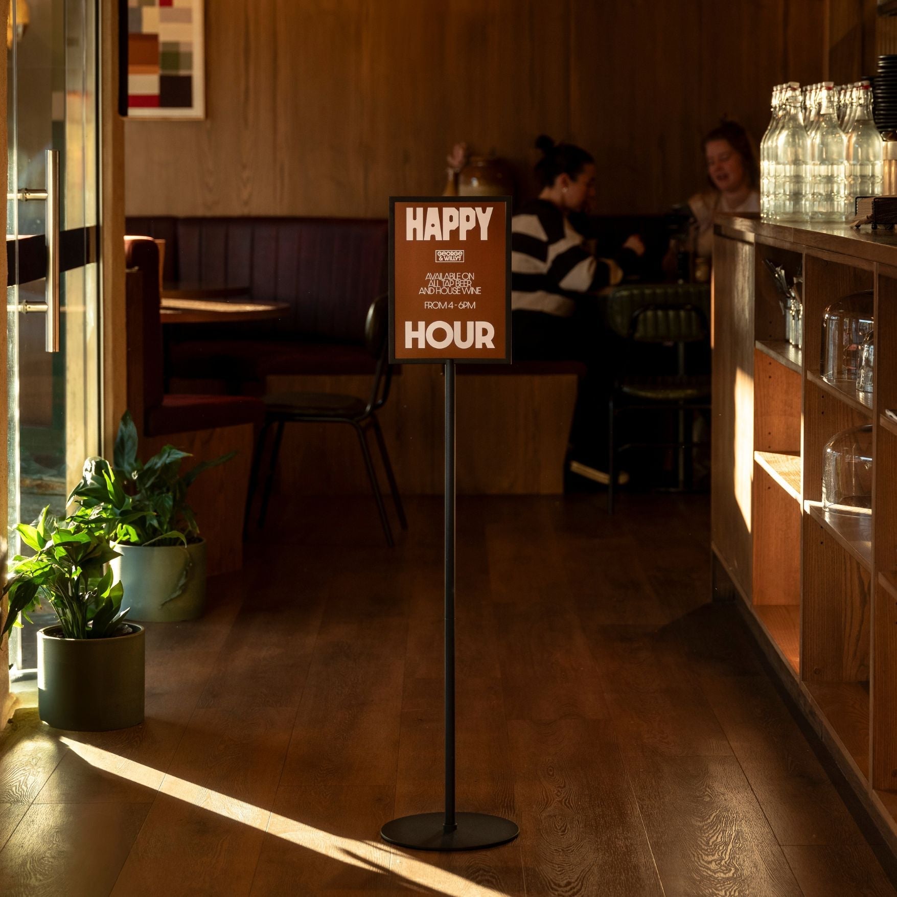 black framed standing sign holder inside a restaurant with a sign displayed
