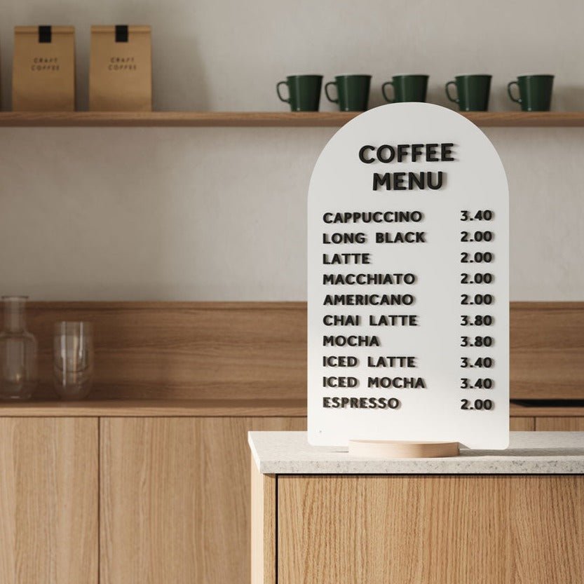 white arch tabletop sign on a wooden countertop