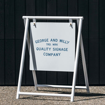 Black A Frame sandwich board sign outside shop front, showing business logo