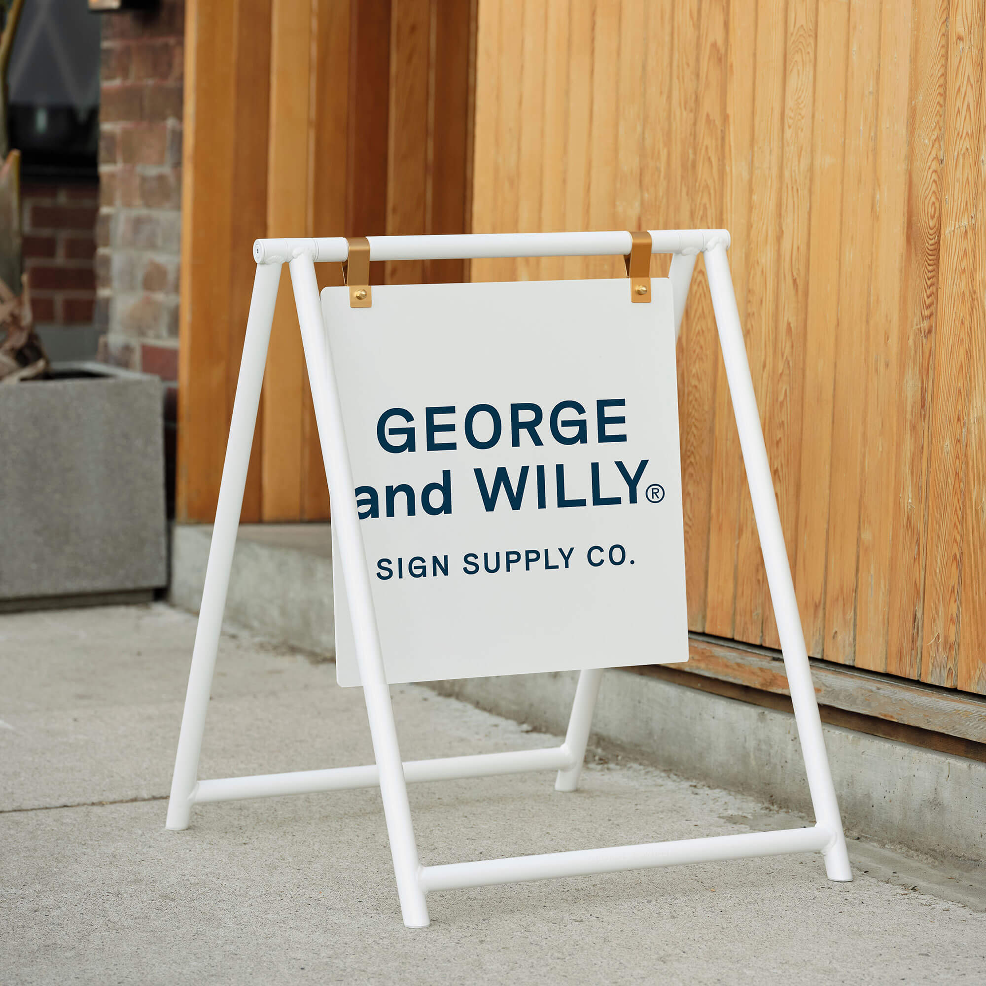 White A Frame sidewalk sign with printed café branding, positioned on pavement by shop front