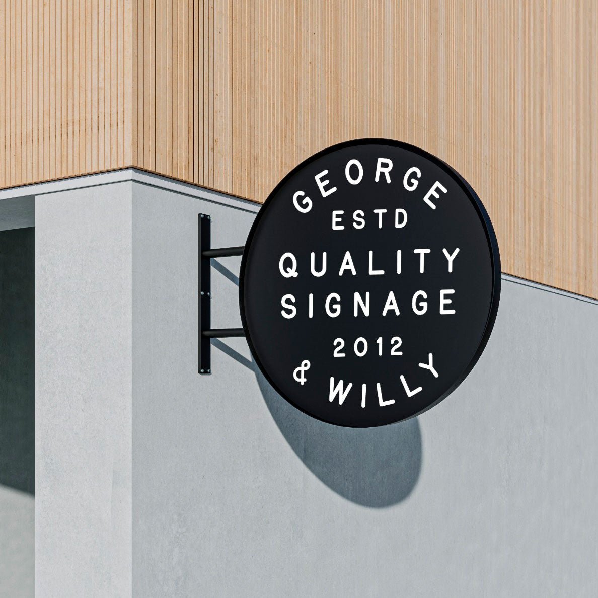 Big round storefront wall signage in black with white text, mounted on concrete and wood wall