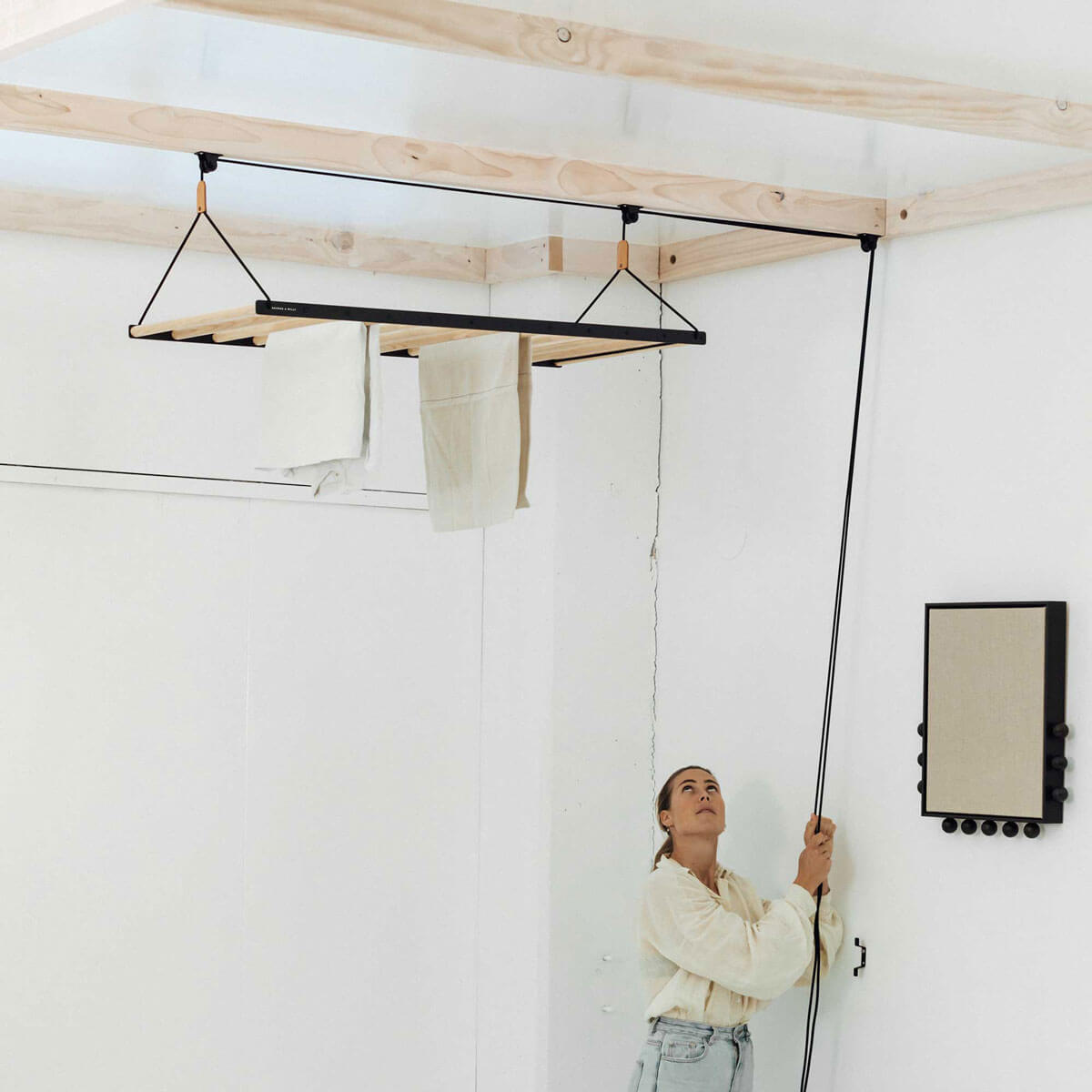 person pulling ceiling hanging drying rack up