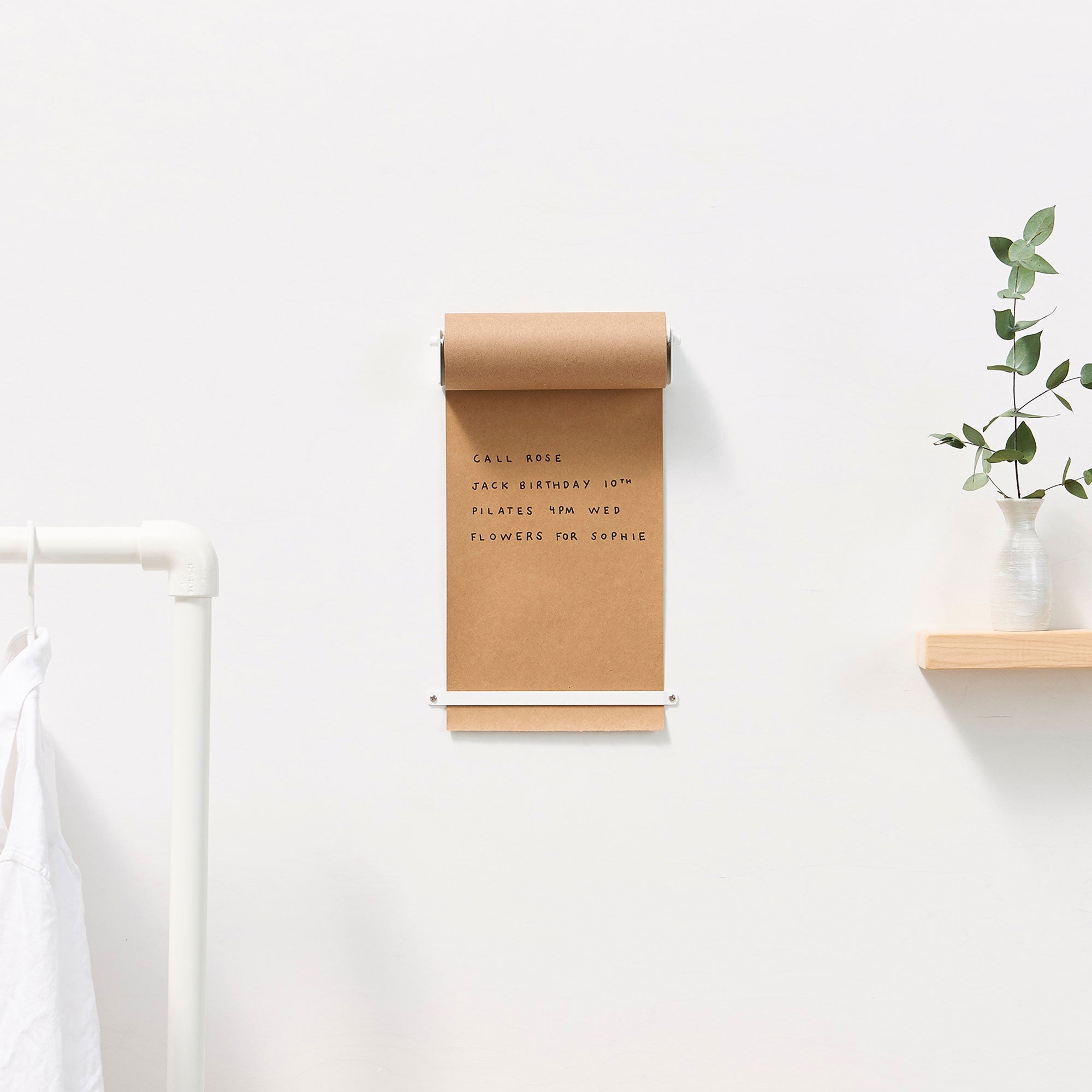 daily roller installed on a wall showing brown paper dispenser with to do list written on it