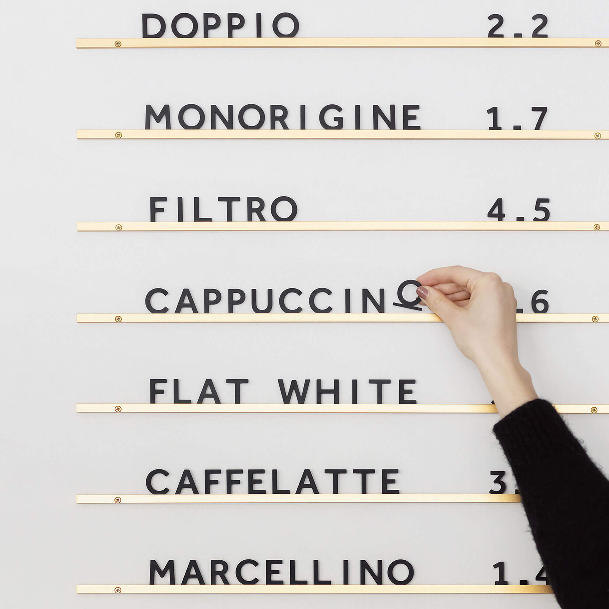 hand adjusting letters on atelier menu board