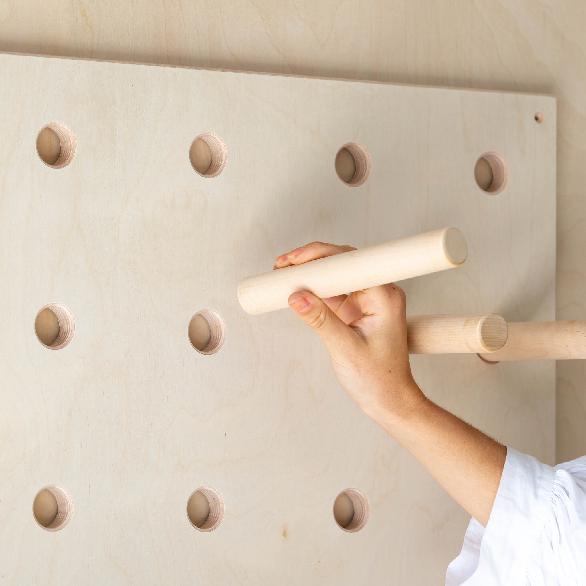 hand installing the pegboard shelves into the board itself