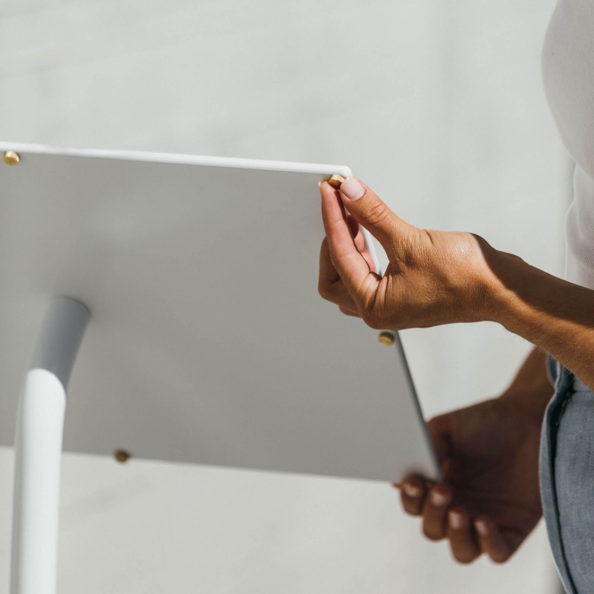 close up of the back of the white menu stand with person holding two sides to show detail